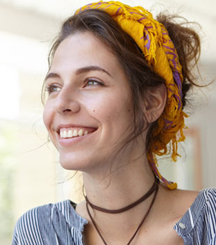 young female wearing a yellow bandana and smiling. image for cancer organisation