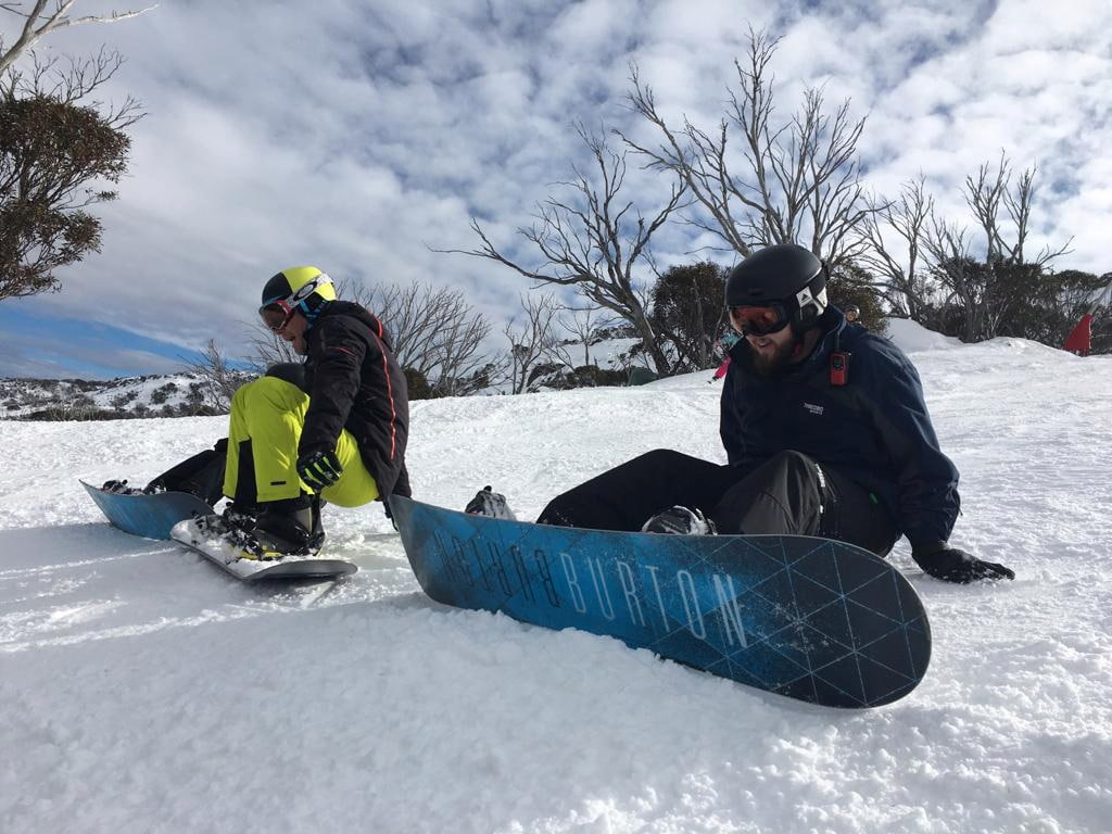 two young people snowboarding