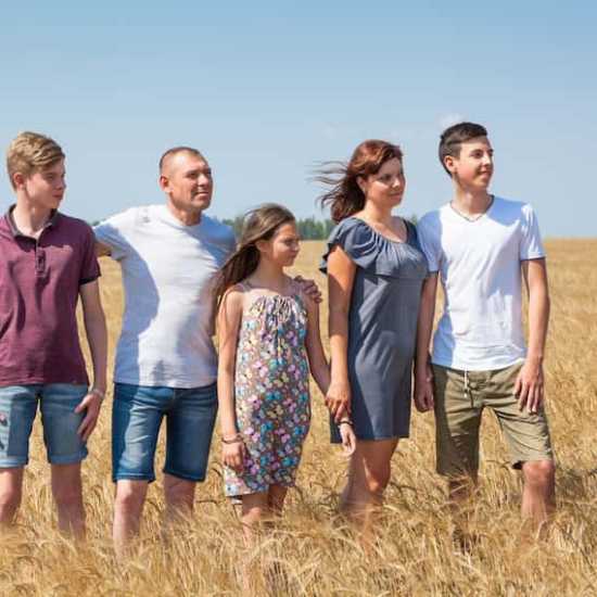 a family impacted by cancer standing together in a field