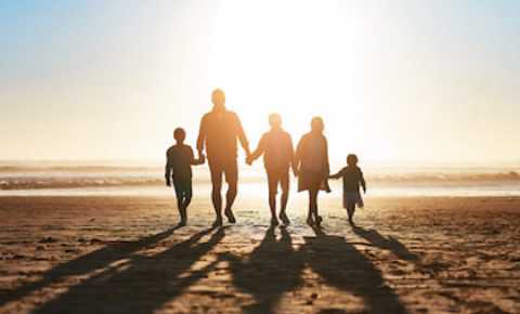 family of 5 walking on the beach together