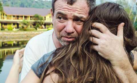 Upset father hugging daughter