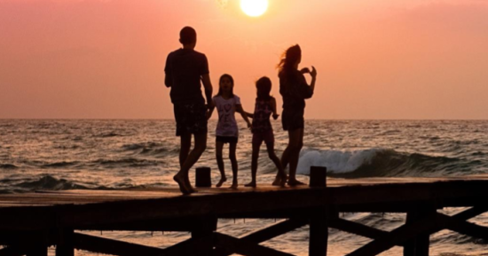 family at the beach at sunset