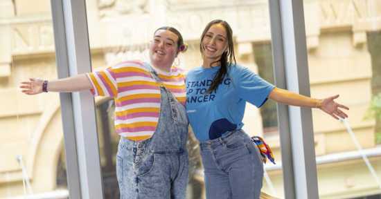 two young girls posing for the camera embracing