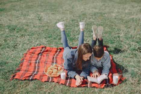 Siblings reading in a park