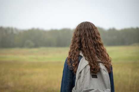 Girl with backpack looking into distance