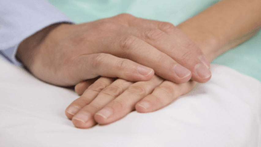 Hands clasping in palliative care