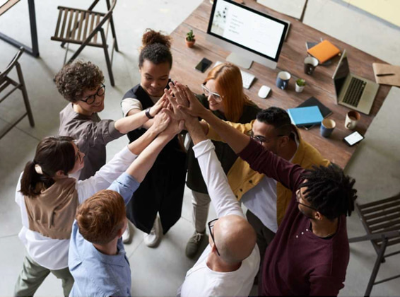 group hi 5 behind a work or study table