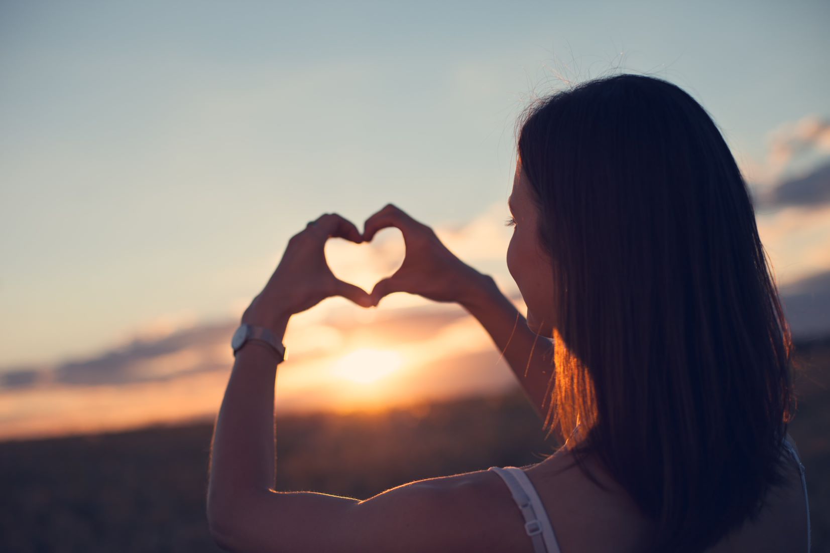 girl making a heart sign with her hands