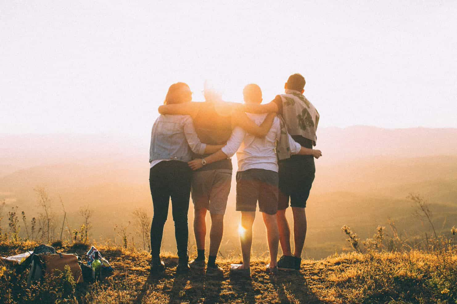 four friends hugging on a hill