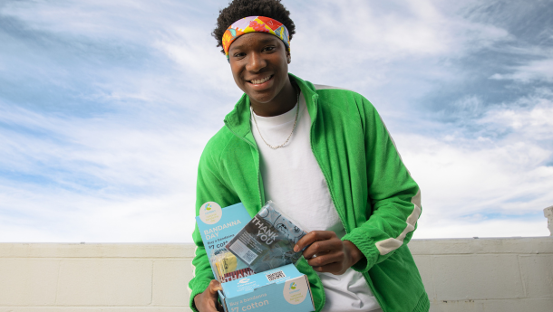 young person sells bandannas from a box