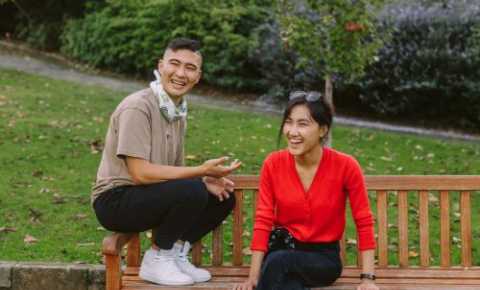 two young people sitting in a park